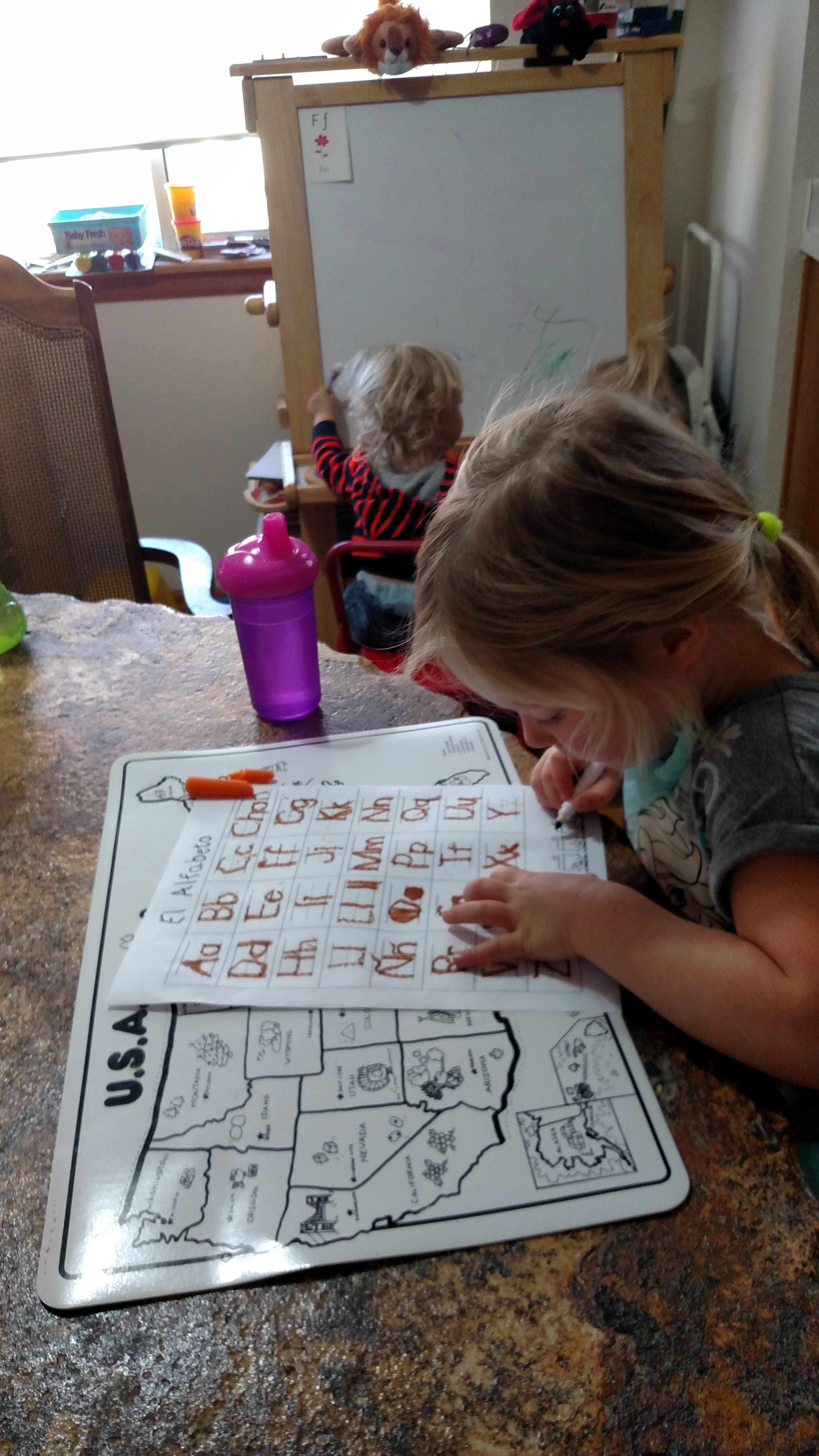 Child working on an alphabet activity at a table