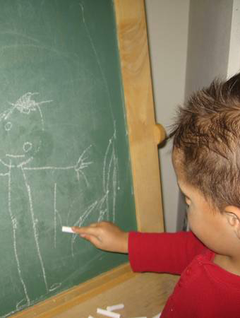 Child drawing on a chalkboard