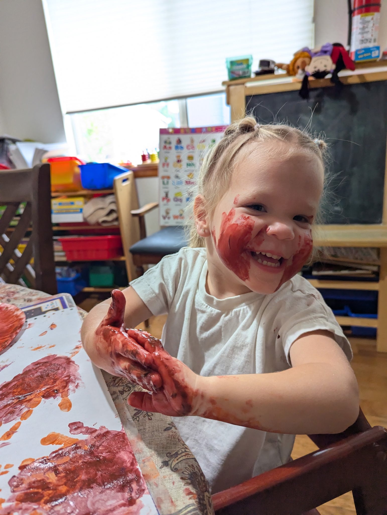 Child painting during an indoor childcare activity